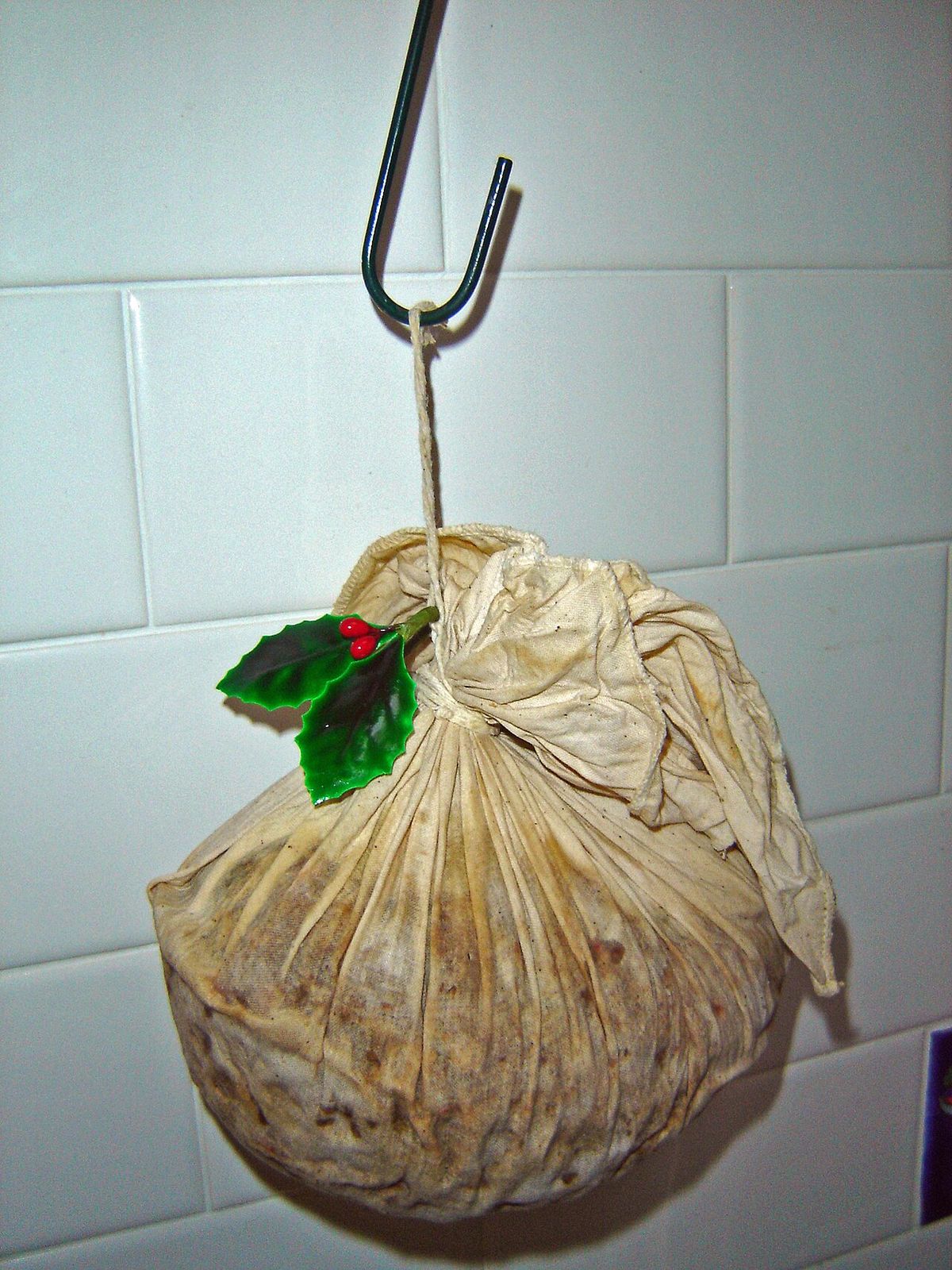 A Christmas pudding hanging on a hook to dry.