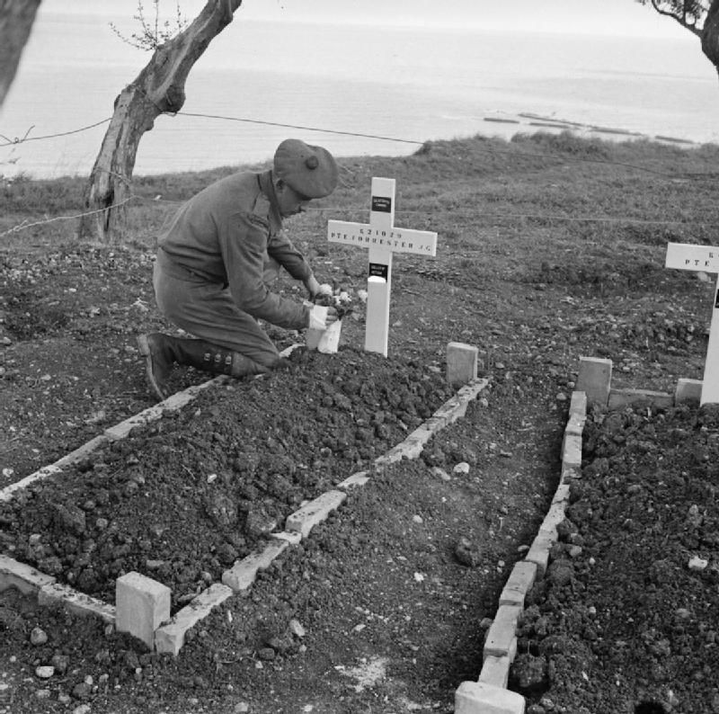 The Canadian Army in Italy 1944 Private Ralph Forrester of the Seaforth Highlanders of Canada places flowers on the grave of his brother kil