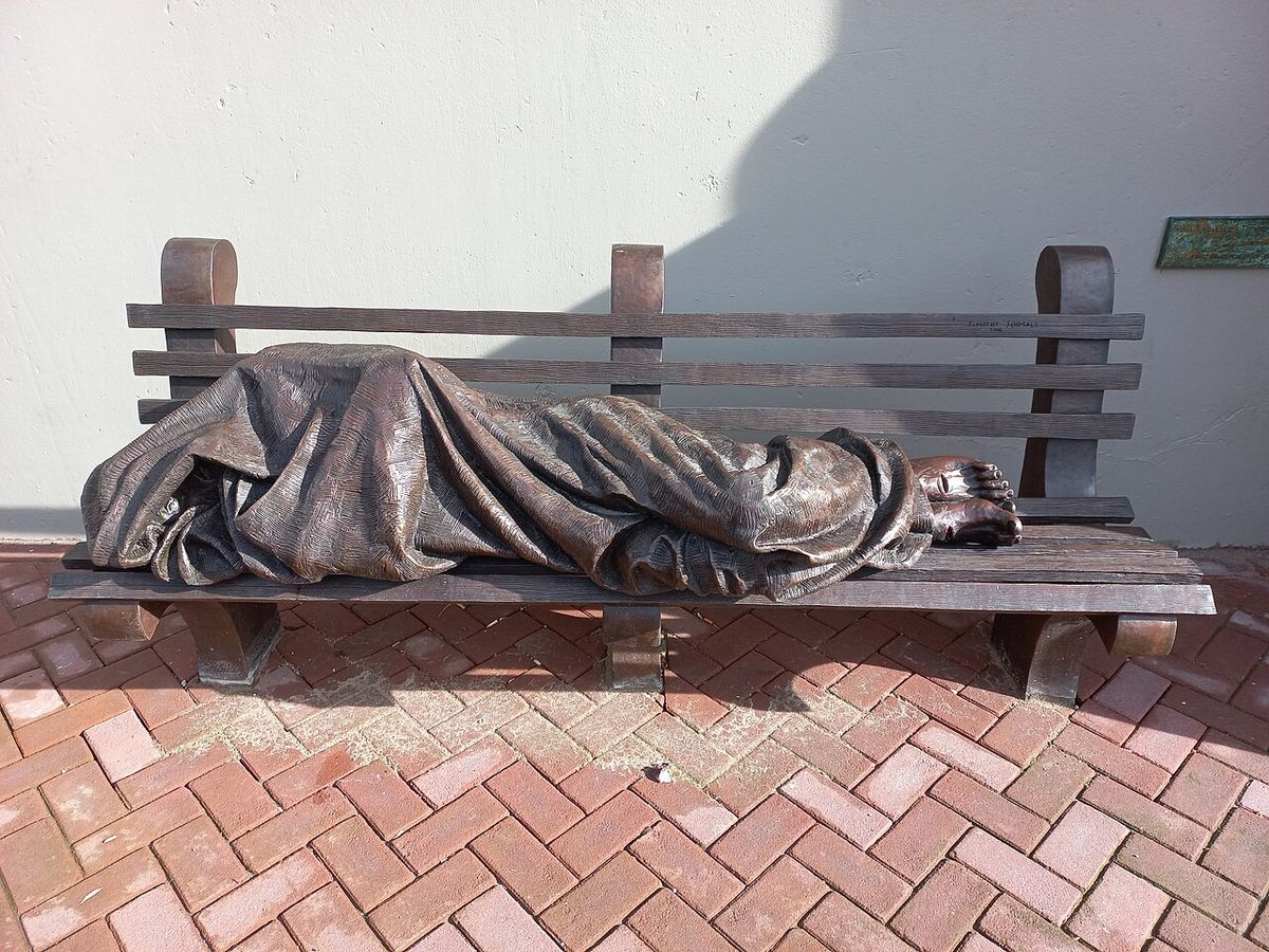 Jezus als daklozen van Schmalz naast de Mozes en Aäronkerk, Waterlooplein, Amsterdam